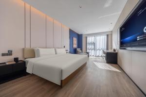 Televiisor ja/või meelelahutuskeskus majutusasutuses Atour Hotel Wefang High Tech Zone Management Committee East Jiankang Street