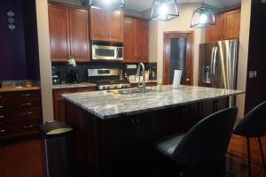 カルガリーにあるCozy Comfort Rooms in SE Calgary, Canadaのキッチン(木製キャビネット、花崗岩のカウンタートップ付)
