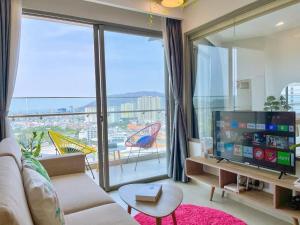 a living room with a couch and a large window at The Sóng Vũng tàu -Thuỷ còi in Vung Tau