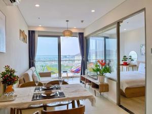 a bedroom with a bed and a dining room with a view at The Sóng Vũng tàu -Thuỷ còi in Vung Tau