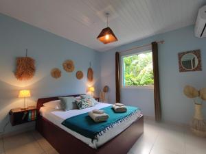 a bedroom with a bed with towels on it at Location Touristique Des Tortues in Deshaies +36 photos