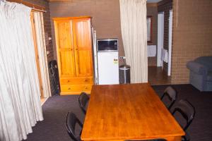einen Tisch mit Stühlen und einen Kühlschrank im Zimmer in der Unterkunft Mildura Motor Inn in Mildura