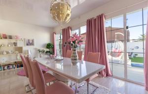 ein Esszimmer mit einem weißen Tisch und rosa Stühlen in der Unterkunft 3 Bedroom Cozy Home In Rojales in Rojales