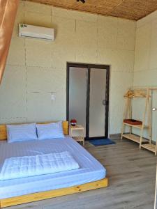 une chambre avec un grand lit dans une pièce dans l'établissement Hòn Đỏ Homestay Ninh Thuan Venuestay, à Mỹ Thanh