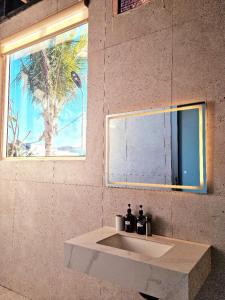 La salle de bains est pourvue d'un lavabo, d'une fenêtre et d'une fresque murale. dans l'établissement Hòn Đỏ Homestay Ninh Thuan Venuestay, à Mỹ Thanh