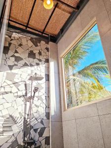 La salle de bains est pourvue d'une fenêtre et d'un mur en carrelage. dans l'établissement Hòn Đỏ Homestay Ninh Thuan Venuestay, à Mỹ Thanh