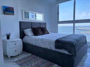a bedroom with a large bed and a large window at The Sands vista al mar Panamá avenida Balboa in Panama City +11 photos