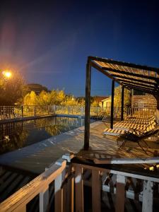 a boardwalk with chairs and a pergola at night at Cabaña rincón del salto in Cabrero