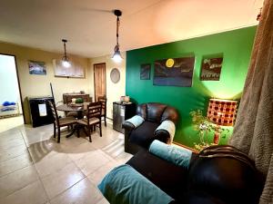 a living room with a couch and a green wall at Cabaña rincón del salto in Cabrero