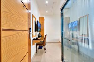 a room with a desk with a chair and a glass door at S79 Son Mi Hotel Saigon in Ho Chi Minh City
