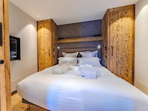 a bedroom with a large white bed with towels on it at Appartement 3 chambres à Méribel, service 5* - FR-1-613-138 in Les Allues