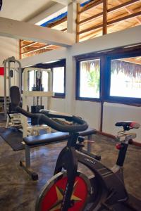 a gym with a bike in a room with windows at Casitas en Vichayito, a Pasos de la Playa in Los Órganos