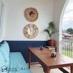 a living room with a wooden table and a mirror at Aline Villa in Wonosobo