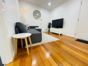 ローズバッドにあるPerfect Family Home pet-friendly in Rosebud plus BBQのソファとテーブルとテレビのあるリビングルーム