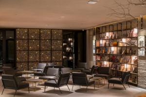 a library with chairs and tables and bookshelves at Jiayuguan Tuzhu Hotel in Jiayuguan