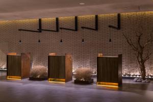 a row of wooden stalls in front of a brick wall at Jiayuguan Tuzhu Hotel in Jiayuguan