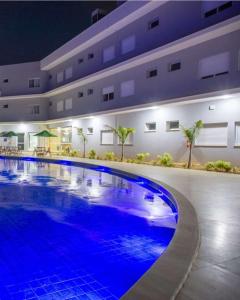 a large swimming pool in front of a building at Comfort Hotel Serra da Canastra in São João Batista do Glória