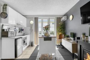 a kitchen with white appliances and a living room at Beach-Side Studio Apt with parking spot in Melbourne