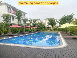 a swimming pool with chairs and umbrellas next to a building at Blue Sea Hue Hotel in Hue
