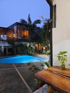 a house with a swimming pool and a wooden table at Hotel Capilla del sol in Garzón