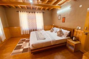a bedroom with a large bed in a room at Green Tara Homestay by StayApart in Tabo
