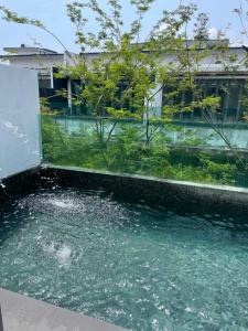 a pool of water in front of a building at Luxury, Affordable and Spacious Private Villa with Swimming Pool & Jacuzzi for 20 plus ppl Cyberjaya in Cyberjaya