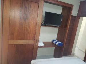 a wooden cabinet with a television in a bedroom at Vamar Apartamentos in San Felipe de Puerto Plata