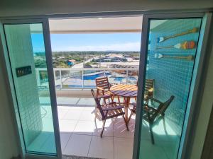 a balcony with a table and chairs and a view of a pool at Sunset World, Le Bon Vivant Arraial do Cabo - Vista mar, ar condicionado e wifi in Arraial do Cabo
