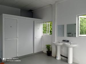 een witte badkamer met 2 wastafels en een raam bij Dream Sun in Weligama