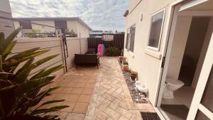 a small patio with a toilet on a balcony at Beachside Bliss in Tauranga