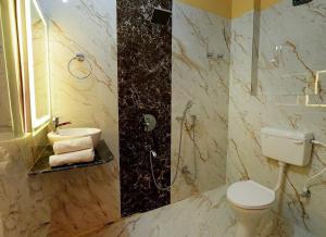 a bathroom with a shower and a toilet and a sink at Hotel RJ in Patna +45 photos