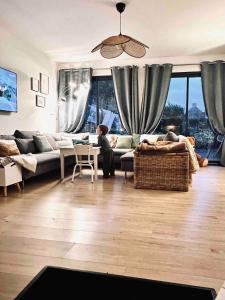 una sala de estar con una persona sentada en un sofá en Charming beach house, Les Embruns, en Hermanville-sur-Mer