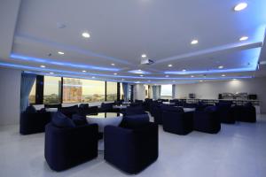 a large room with couches and tables and windows at 幸福星空時尚旅館 in Luodong