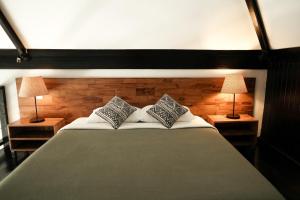 a bedroom with a large bed with two lamps at Wave House Boutique Surf Retreat - Adults Only in Canggu +29 photos