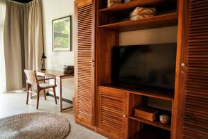 a living room with a television and a table at Wave House Boutique Surf Retreat - Adults Only in Canggu