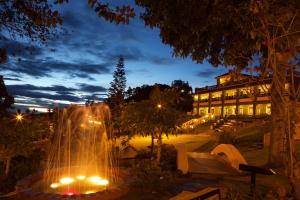 a fountain in front of a building at night at Green Pastures - A Hill Country Resort in Kodaikānāl