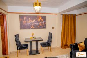 a living room with a table and chairs and a fireplace at Bahati homes 2 in Kisii