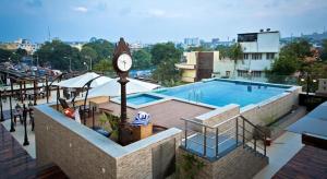 a clock next to a swimming pool with a clock tower at Ramada Chennai Egmore in Chennai