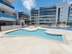 an empty swimming pool in front of a building at Sunset World, Le Bon Vivant Arraial do Cabo - Vista mar, ar condicionado e wifi in Arraial do Cabo
