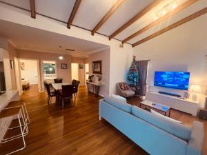 a living room with a blue couch and a tv at Cosy Homes - 15 Minutes Away From Melbourne Airport in St Albans