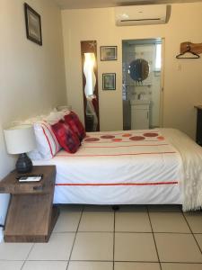 1 dormitorio con 1 cama y 1 mesa con lámpara en Black Marlin Motel en Innisfail