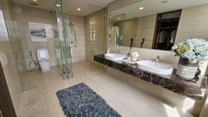a bathroom with two sinks and a glass shower at Morich Penthouse Jakarta in Jakarta +38 photos