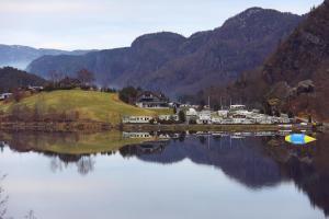 a large body of water with houses and mountains in the background at Egenes Camping in Flekkefjord