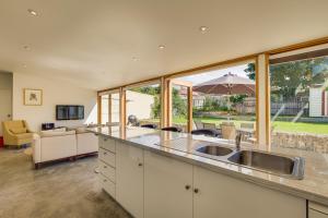 a kitchen with a sink and a living room at Brampton Cottage in Hobart