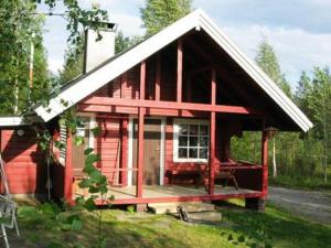 een rode hut met een wit dak en een veranda bij Loma Rinteelä in Suonenvaara