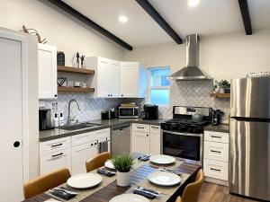 a kitchen with white cabinets and a table with chairs at Redwood Oasis - Private Heated Pool by State Park! in Felton