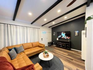 a living room with a couch and a tv at Redwood Oasis - Private Heated Pool by State Park! in Felton