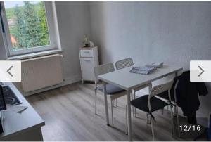 a table and chairs in a room with a window at Monteurwohnung bei Nina 2OGL in Zeitz
