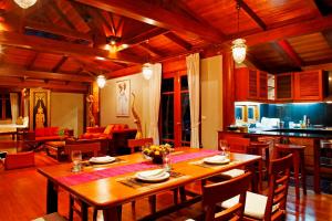 a dining room with a table and a living room at Surin Beach Villa 3 bedrooms in Surin Beach
