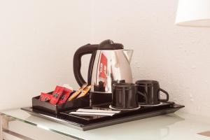 a black tray with a tea kettle and two mugs at Hotel Medicis in Barcelona